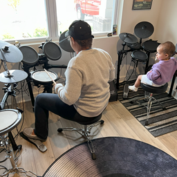 Myaddy with kid playing drums.
